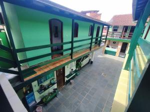 Cette chambre offre une vue sur une maison aux murs verts. dans l'établissement Pousada Taquinha Paraty, à Parati