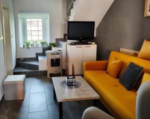 un soggiorno con divano giallo e TV di Ferienhaus Maja - a76148 a Pavicini