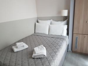 a bedroom with a bed with towels on it at Dimitra Boutique Hotel in Poros