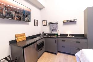 cocina con fregadero y encimera en Thena Hotel - Cozy Studio, en Filadelfia