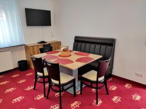 バイアースブロンにあるWellness Hotel Garni Kroneの赤いカーペットのテーブルと椅子が備わる部屋