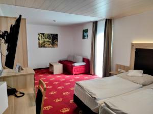 バイアースブロンにあるWellness Hotel Garni Kroneの赤いカーペットフロアの客室で、ベッド2台が備わります。