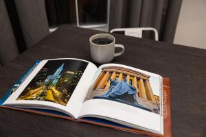 Thena Hotel - Beautiful 1 Bedroom في فيلادلفيا: كتاب مفتوح على طاولة مع كوب من القهوة