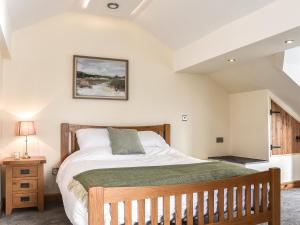 a bedroom with a bed with a wooden bed frame at Y Parlwr in Kidwelly