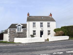 una casa blanca al lado de una carretera en Y Parlwr, en Kidwelly