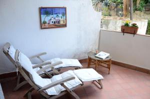 Habitación con mesa y 2 mecedoras en Sea Breeze Acitrezza, en Aci Castello