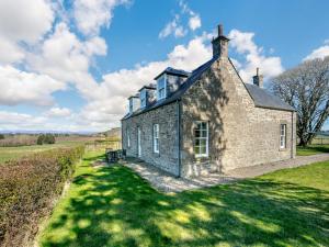 una vieja casa de ladrillo en medio de un campo en Meadowgreen Farmhouse, en Forfar