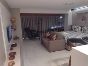 sala de estar con cama y sofá en apartamento 5 estrelas bela vista, en São Paulo