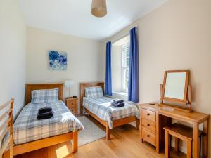 1 dormitorio con 2 camas, espejo y escritorio en Meadowgreen Farmhouse, en Forfar