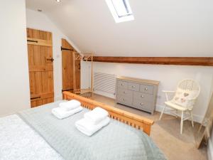 1 dormitorio con 1 cama y 1 silla en The Old Stable en Conwy