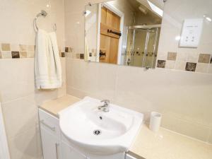 a white bathroom with a sink and a mirror at The Old Stable in Conwy +22 photos