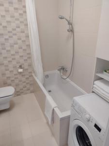 a bathroom with a washing machine and a toilet at Apartament Zdrój in Krzeszowice