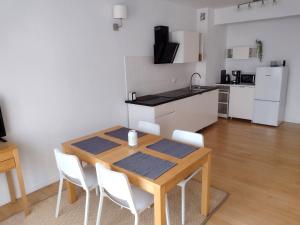 a kitchen and dining room with a wooden table and chairs at Apartament Zdrój in Krzeszowice