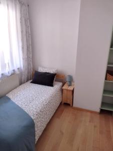 a small bedroom with a bed and a window at Apartament Zdrój in Krzeszowice