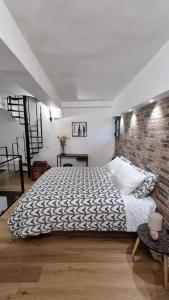 um quarto com uma cama e uma parede de tijolos em Home Catania Dante Accommodations em Catânia