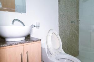 een badkamer met een wastafel, een toilet en een spiegel bij Apartamento viajes de trabajo en el norte in Montería