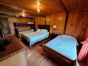 a bedroom with two beds in a wooden cabin at Hermosa cabaña en Lago Ranco in Lago Ranco