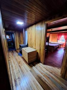 Cette chambre dispose de parquet et d'une table en bois. dans l'établissement Hermosa cabaña en Lago Ranco, à Lago Ranco