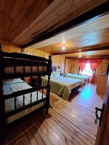 - une chambre avec 2 lits dans une chambre dotée de parquet dans l'établissement Hermosa cabaña en Lago Ranco, à Lago Ranco