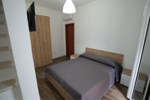 Un pequeño dormitorio con una cama y un televisor. en La stradina, en Mola di Bari