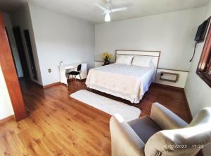 a bedroom with a bed and a living room with a couch at Pousada com vista para o Cristo 3 in Encantado