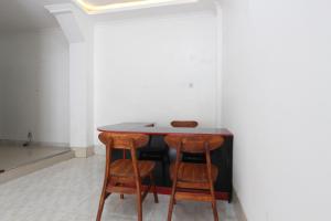 SPOT ON 92434 Puri Kasih Guest House Syariah في سولو: طاولة وكرسيين في غرفة