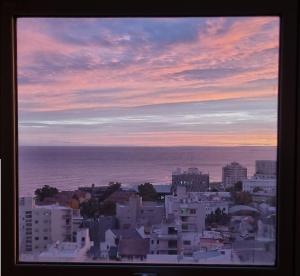 una vista da una finestra di una città con l'oceano di Infinito - Departamento con vista al mar a Comodoro Rivadavia