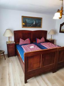 um quarto com uma cama de madeira com almofadas vermelhas e brancas em Ferienwohnung ADAM im Haus Heidi em Höchenschwand