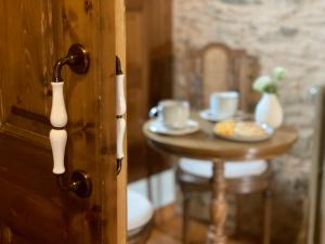 a wooden door with a table with cups on it at Casa de 3 habitaciones in Coirós