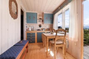 uma cozinha com mesa e cadeiras num quarto em Koselig og usjenert hytte med fantastisk utsikt og solforhold 