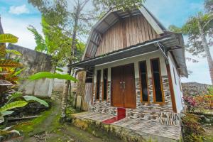 a small wooden house with a red door at SPOT ON 92462 Awenk Homestay in Lombok