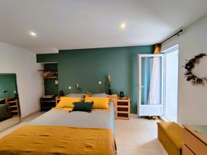 ein Schlafzimmer mit einem großen Bett und einer grünen Wand in der Unterkunft Gîte de la Petite vallée in Saint-Savinien