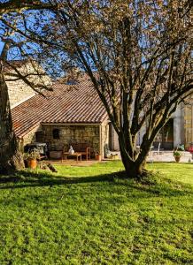 ein Haus mit einem Tisch und einem Baum im Hof in der Unterkunft Gîte de la Petite vallée in Saint-Savinien