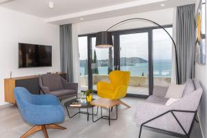 un soggiorno con sedie gialle e blu e TV di Luxury Villa Helios 5* a Dubrovnik