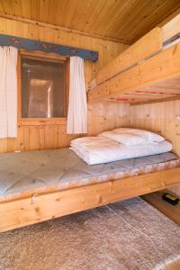 two bunk beds in a log cabin with a window at Koselig og usjenert hytte med fantastisk utsikt og solforhold 