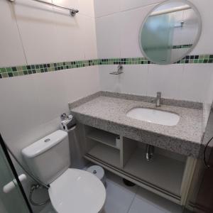 a bathroom with a toilet and a sink and a mirror at Flat Maresias 50m da Praia - 06 Mar & Tur in Maresias +19 photos