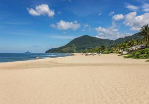 a sandy beach with a view of the ocean at Flat Maresias 50m da Praia - 06 Mar & Tur in Maresias