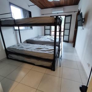 two bunk beds in a room with a tiled floor at Flat Maresias 50m da Praia - 06 Mar & Tur in Maresias