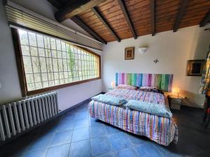 a bedroom with a bed and a large window at Le Mulina in Barberino di Mugello