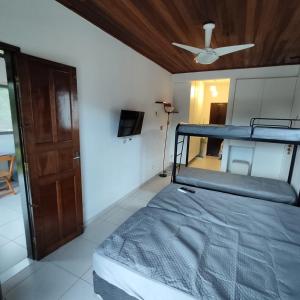 a bedroom with a bunk bed with a ceiling fan at Flat Maresias 50m da Praia - 06 Mar & Tur in Maresias
