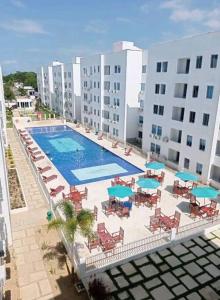 einen Blick über einen Pool mit Stühlen und Sonnenschirmen in der Unterkunft Genial apartamento de playa! coveñas in Coveñas