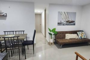 ein Wohnzimmer mit einem Sofa und einem Tisch in der Unterkunft Genial apartamento de playa! coveñas in Coveñas