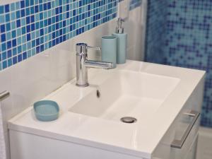 un lavandino bianco in un bagno con piastrelle blu di Annarosa Home a Vico Equense