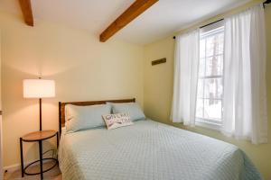 1 dormitorio con cama y ventana en Cozy Tuftonboro Home with Deck - Walk to Beaches! 