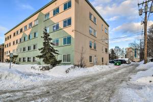 a snow covered street in front of a building at Anchorage Vacation Rental in Walkable Area! in Anchorage