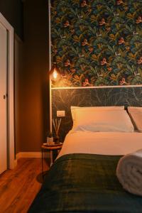 a bedroom with a bed with a large painting on the wall at Il Corso Comfort Rooms in Rome