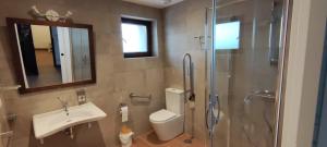 a bathroom with a toilet and a sink and a shower at LA LÍNEA DEL MAR in Trasierra +32 photos
