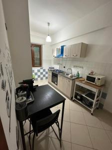 una piccola cucina con un tavolo e una stufa di Dimora Anema e Core a Napoli