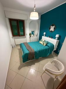 una camera blu con un letto e una sedia di Dimora Anema e Core a Napoli