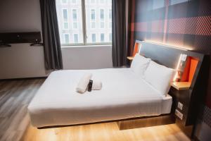 una camera d'albergo con un letto e un asciugamano sopra di easyHotel Paris Nord Aubervilliers ad Aubervilliers